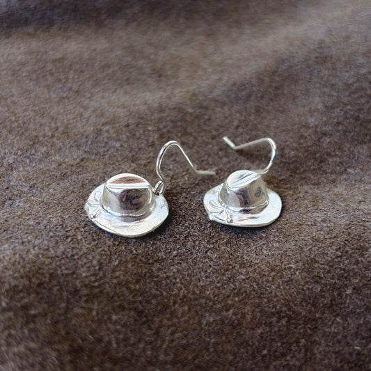 Huat-Ohrringe aus Silber, Paar auf braunem Leder