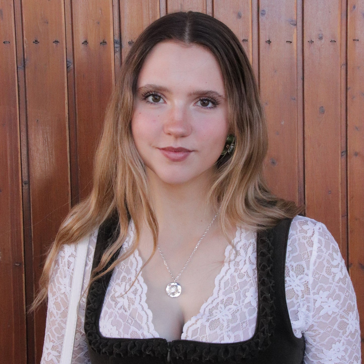 Model im dunklen Samt-Dirndl mit Huat-Halskette von Trachtstück